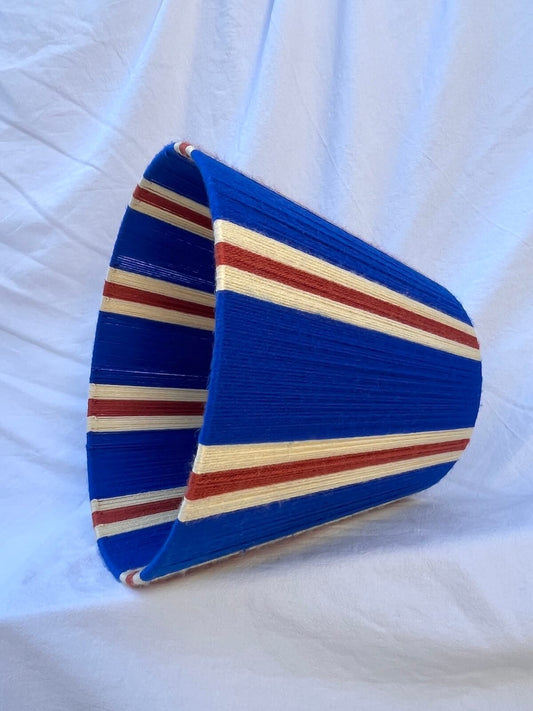 A Slice Shades handwoven striped yarn lampshade in cobalt blue, butter yellow and burnt orange stripes.