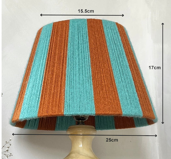 A Slice Shade striped yarn lampshade with vertical bands of turquoise, and burnt orange shown with dimension arrows and labels indicating 15.5cm width, 17cm height, and 25cm base diameter.