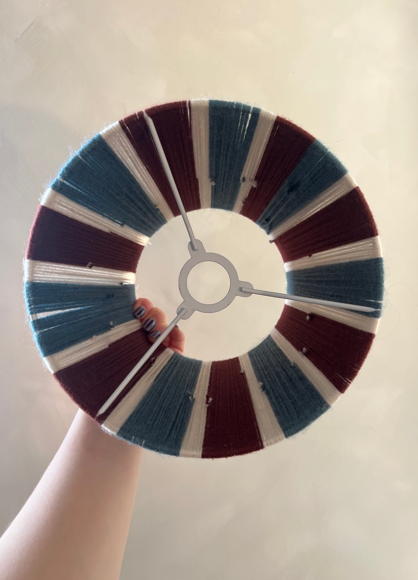 A Slice Shades handmade yarn lampshade held so you can see the inside of the lampshade.
